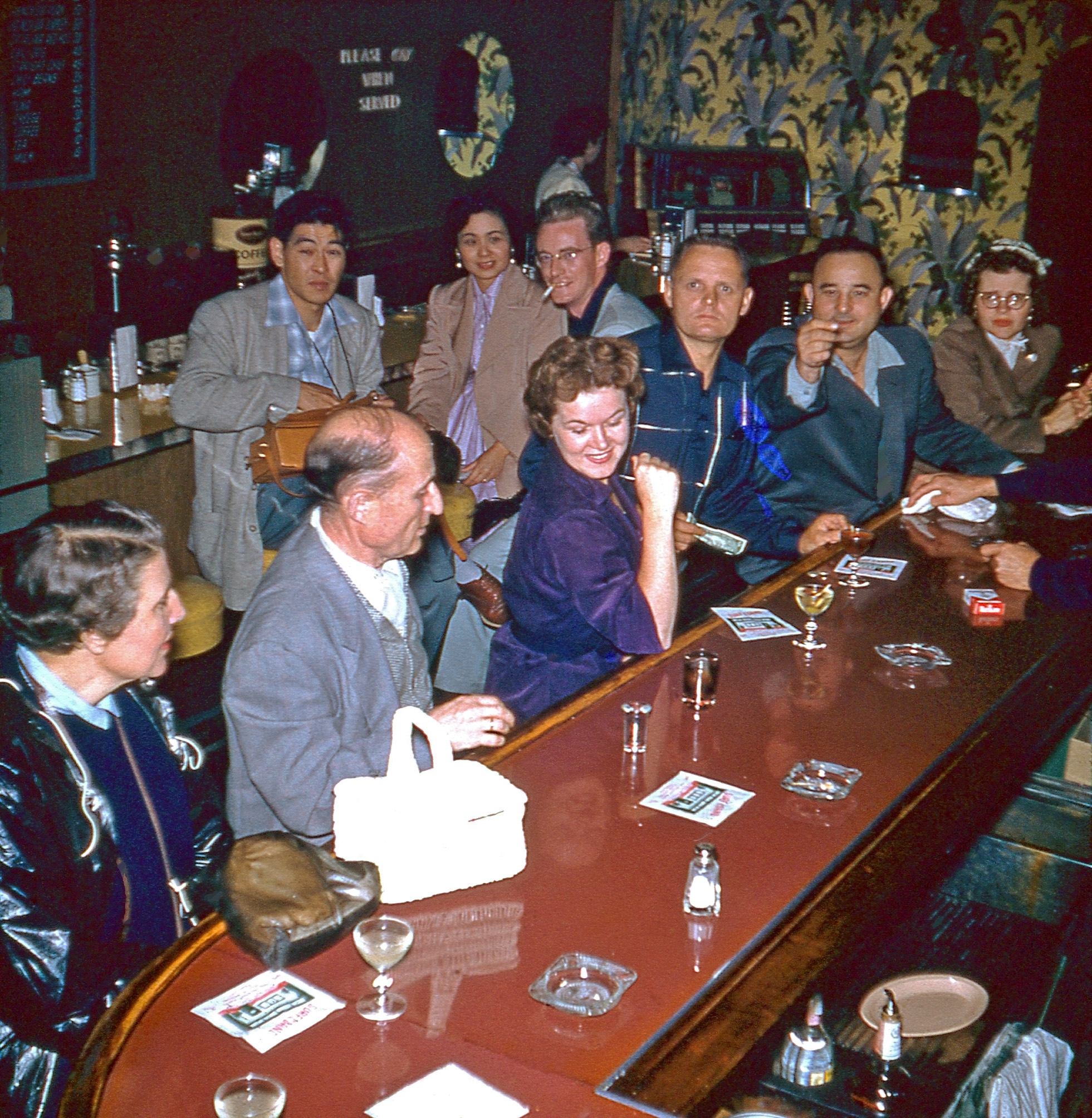 Mid-50s bar scene, possibly in the Los Angeles area. From one half of a stereo slide I found in a thrift store. If the resolution was just a bit higher we could get a name off those napkins. View full size.