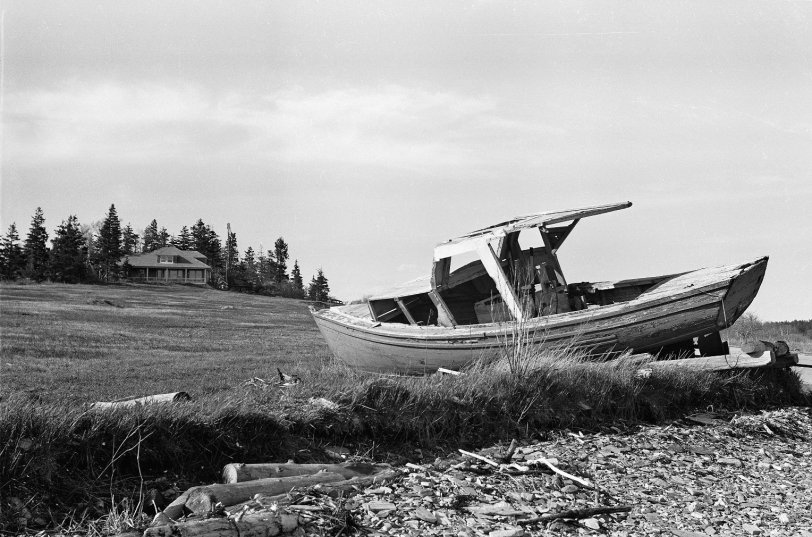 Washed up lobster boat, somewhere in Maine. Time to go invest in another boat. From my negatives collection. View full size.
