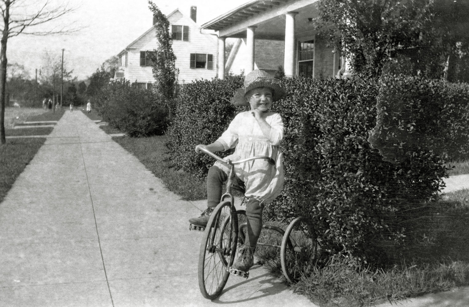 Young girl happily riding around the neighborhood on her tricycle. From my negatives collection. View full size.