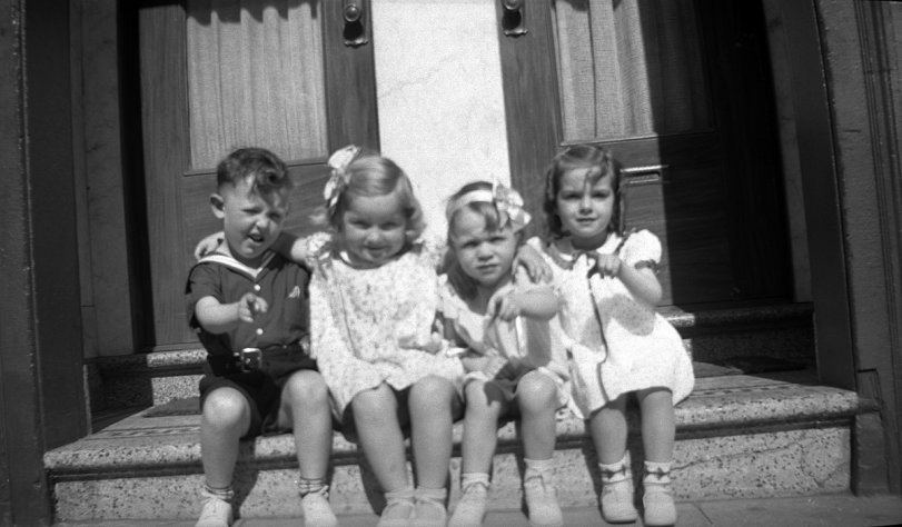 My sister (at right) and her guests for her third birthday party, arrayed across the terrazzo front steps of their apartment on Ramona Ave. in San Francisco, 1937. View full size.
