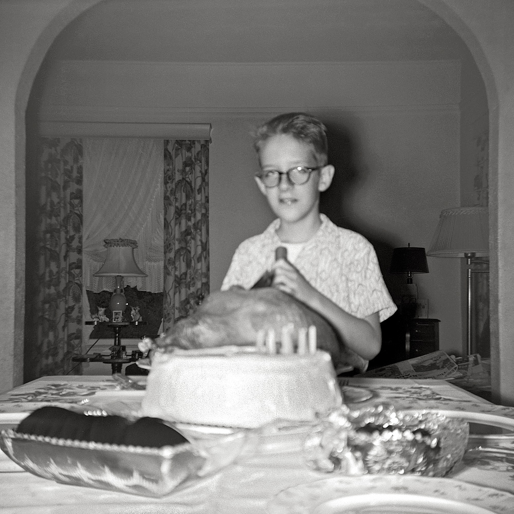 August 15, 1955. My ninth birthday. In answer to my request, we had turkey with all the trimmings. I'm pretending to carve. The camera this was taken with was probably a birthday present, thereby starting me on my road to photographic immortality. Poetic justice that the shot's out of focus. Gobble gobble.