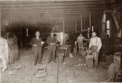 Inside shot of a blacksmith shop. Don't know place it was taken. Appears to have a car from the twenties in the back of the shop. Photographer unknown.
(ShorpyBlog, Member Gallery)