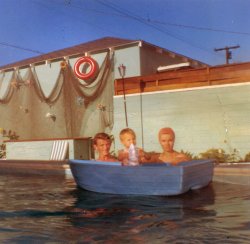 Uncle Roger, cousin Deanna and Aunt Susan taking a dip  the pool. Likely taken in 1961. View full size.
Those cheap blue boats!They used to sell little plastic skiffs like this one at discount stores.  They were made out of plastic similar to the plastic toddler pools you can buy today.  My friend bought one for $7.50 with a small wood paddle at the J.M. Fields store near our house in about 1966.  We used to drag it down the street to the lake in our neighborhood.  We were about 8 years old.  It only held one kid.  I remember watching from the shore.  Eventually the boat sank and was lost.  The lake was big and deep.  What a terribly dangerous "toy." We were always down there unsupervised.  But it sure was fun!
(ShorpyBlog, Member Gallery)