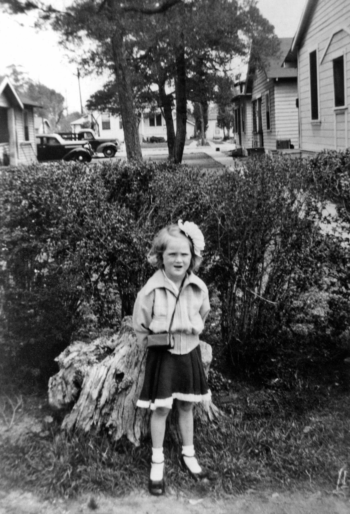 Long before there was a Honey Boo Boo in front of the camera, this little lady was in front of a lens. My suspicion is the buildings behind her are either the cabins of a resort, or a roadside motel that she and her family stayed at, and the photo was taken as a souvenir of that vacation. I bought it from an antique store in Simi Valley, California because of the great truck and car behind Miss Missing Teeth. View full size.
