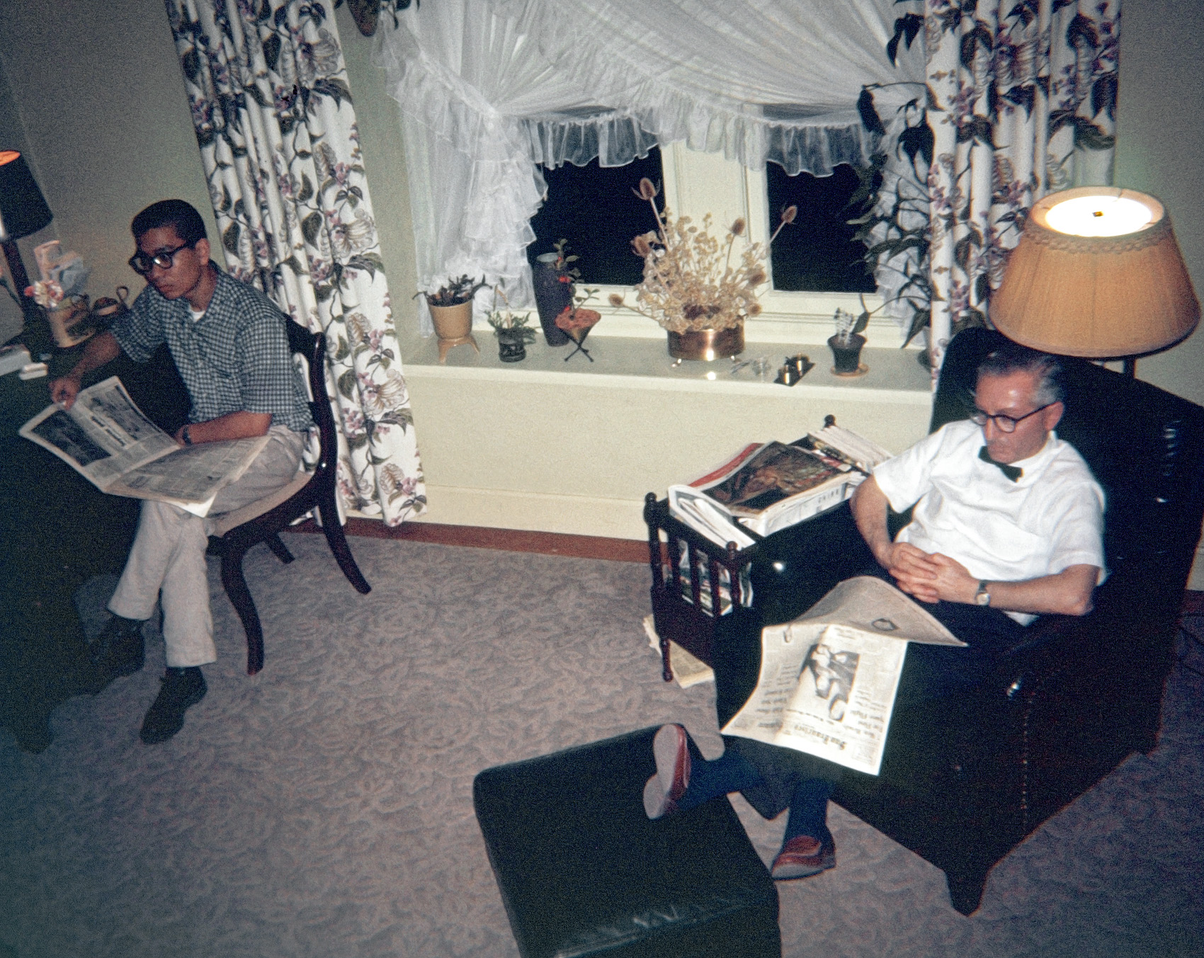 My father, in his comfy leather chair, and our houseguest Bob have their eyes glued to the TV, almost undoubtedly watching the news. We don't know what that news was or its import, but a headline in the San Francisco Examiner reflects an epochal moment: "7 Men Ready for First Space Flight." Three months later Alan Shepard was the one of those Project Mercury astronauts to do it. This 127 Ektachrome transparency has a processing date of February 1961 on the mount.

Bob, a Cal Poly classmate of my brother's, lived with us for a bit while apartment-hunting. Father's clip-on bow tie is actually part of his Jolly Store grocery clerk outfit, indicating he probably just got home, pausing just long enough to slip into his slippers. We also continue the saga of Mother's window treatment, with different-but-similar drapes and curtains. Her love/hate relationship with African violets appears to be in the hate phase at the moment as there are none to be seen. I was standing on the stairway landing, thus the high angle. Man, that leather chair was comfy. View full size.