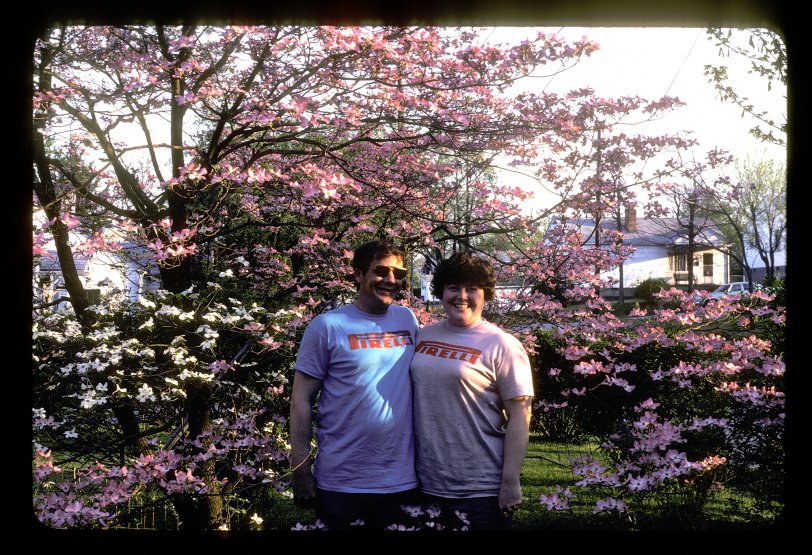 My uncle Butch and aunt Judy in my grandparents' front lawn. Unsure of the exact year but it is early 1980's.  Someone ID the car in the background and that may lend a good idea. My aunt worked at a tire store in Knoxville, TN.  Thus the Pirelli tire T-shirts.  This image just makes me laugh. They are just a hoot. Then and now. Kodak 35mm transparency.
