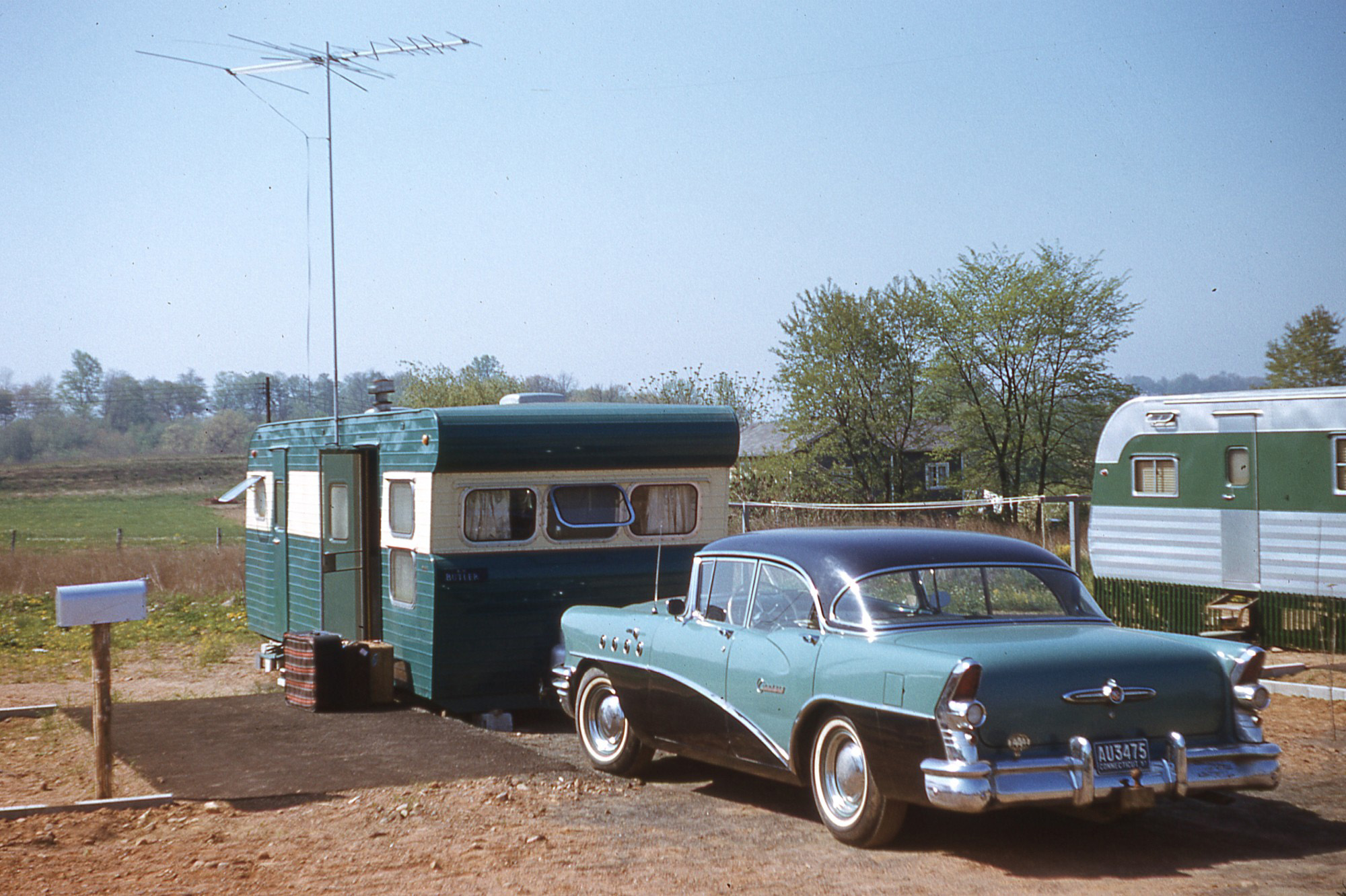 Edward and Gwen Butler, my grandparents, lived in this trailer in Connecticut. It's rather dwarfed by the massive '55 Buick and the 15-foot TV antenna. They had just returned from a trip to England, hence the luggage at the door. Photo by Edward Butler circa 1957 on a 35mm Kodachrome slide, scanned February 2021. View full size.