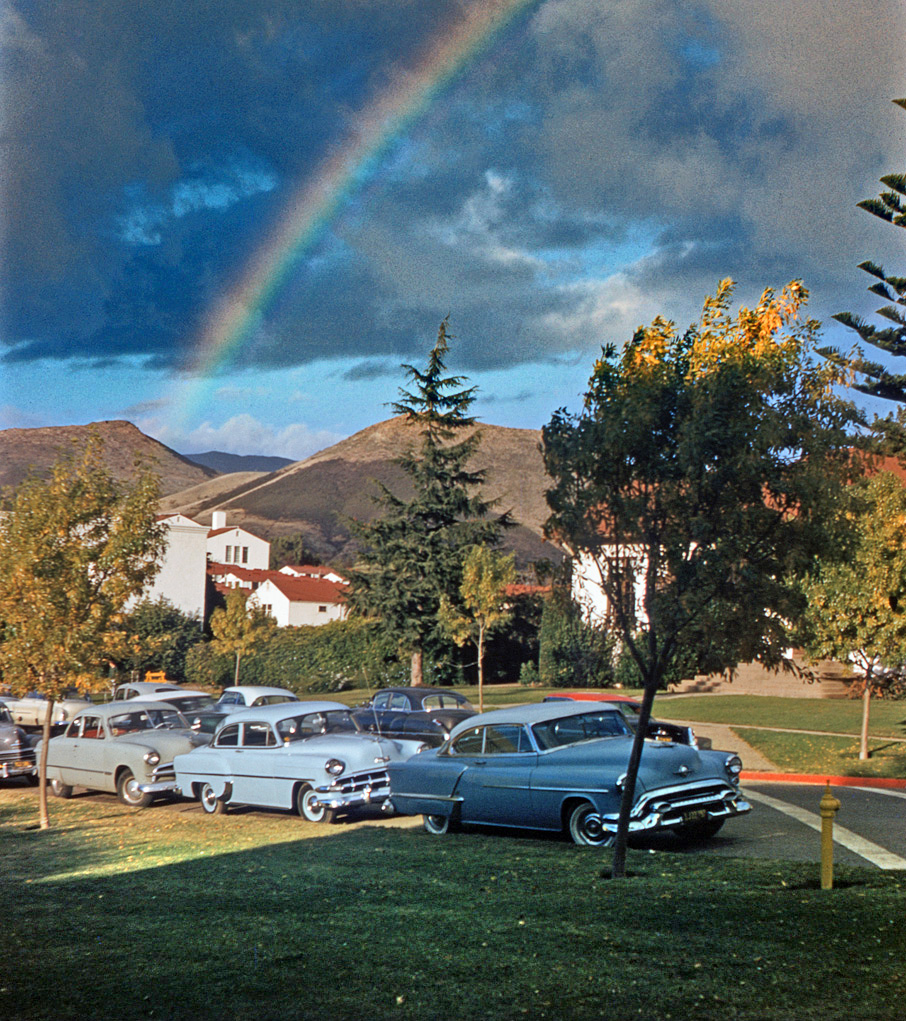 1955. A rainbow over the campus of Cal Poly, San Luis Obispo, seems to end on a row of classic 50s cars. The two-tone '53 Olds is nice, but I wish it wasn't obscuring the red-roofed Merc behind it. Shot by my brother, then a freshman there, on 35mm Kodachrome. View full size.