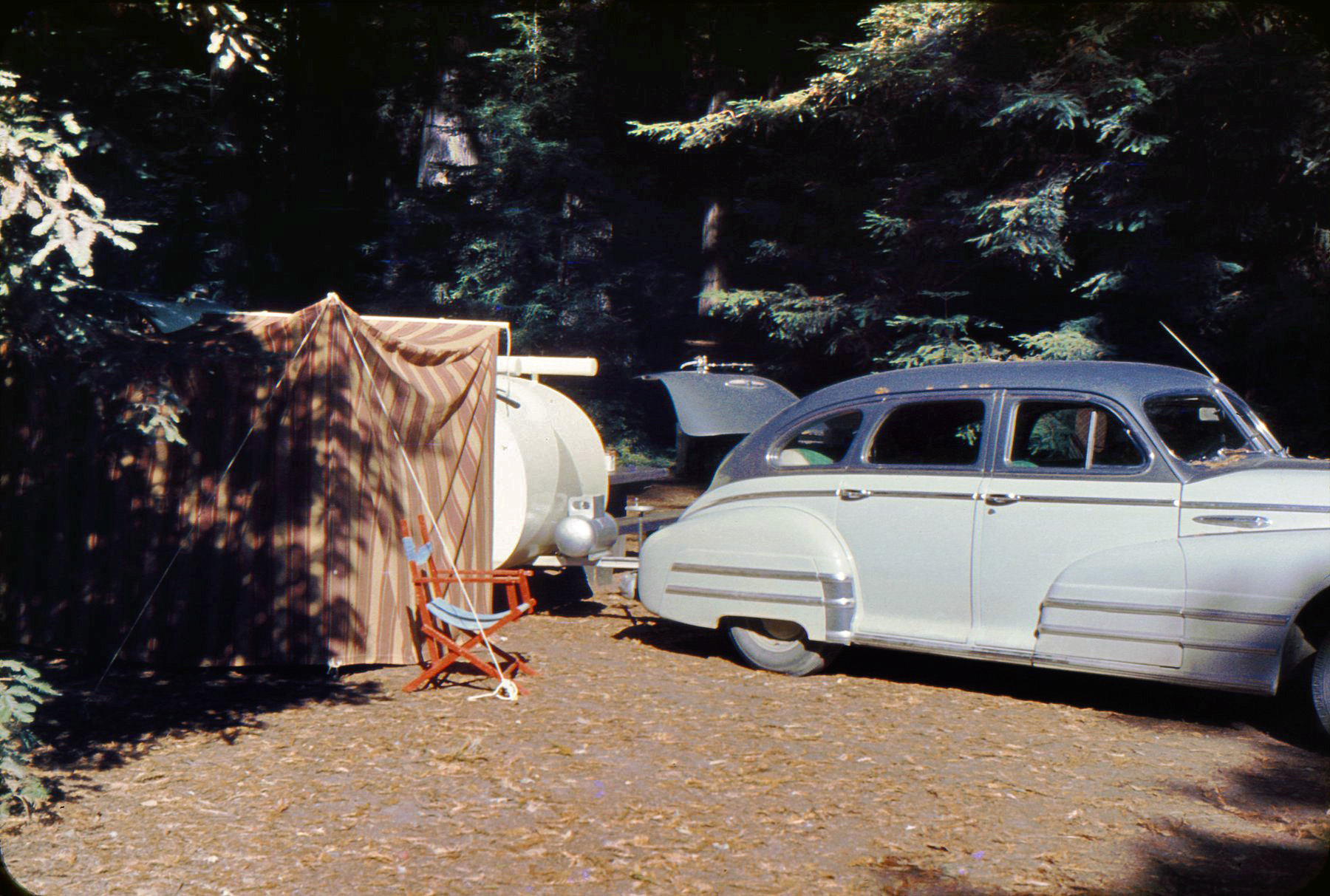 Here's the Blissmobile with the portable kitchen attached. This looks like it could be Yosemite again, in the mid-fifties. 35mm color slide. View full size.