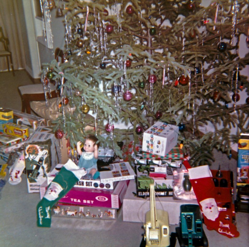 It's Christmas 1962 in the suburban Pennsylvania household of the Bader family, the aftermath of that morning's gift-giving recorded by my grandfather and his trusty Brownie 127.
Despite his relatively modest salary from the Burroughs Corporation, my grandfather did his best to make his children happy each Christmas.  That year, my uncles would each receive a set of Lincoln Logs and a generous helping of war toys, including a toy mortar and helmet, plastic grenades, and a toy tank.  The younger of the two would also get, as seen at right, a set of toy trucks -- two excavators and a fire truck -- and a toy Dairy Delivery set; the elder brother got a set of Play-Doh and a couple of board games.  His daughter -- my mother -- received a Chatty Cathy doll (which she always hated, Barbie being her preferred doll), a set of Play-Doh, and several play tea and homemaking sets.
The disco-ball like Christmas balls seen decorating the tree have served well for decades, and we still use some to decorate trees today.  Sadly, my grandfather can no longer join in the Yuletide celebrations, having passed away in 2009. His spirit lives on, though, in the memories of his children and grandchildren, his life having so enriched our own. View full size.
