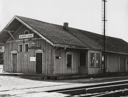 Taken sometime in the 1940's, this is the old C &amp; O Railroad depot in Hurricane, W.Va. Until the 1960's an occasional passenger train stopped here as well as a few freights. If I remember correctly, it was torn down about 1970 and the wood used to build a barn for the Chief of Police. The area then became a parking lot and a rather cheesy gazebo was built later next to the tracks. About 15 or so years ago, the large water tank just down the track was demolished. The switch tower across the tracks was also razed quite a few years ago. I was only about 11 years old when the depot was torn down and even then I was mad as a hornet about it. What makes this so ironic is the fact that Hurricane owes its existence to the railroad, having been moved nearly 2 miles from the James River and Kanawha Turnpike so as to be near the new track in 1873. The only commemoration of our ties to the C &amp; O now are a very small museum in a caboose behind the fire station and a couple of murals on the fire station walls. This image was given to my Aunt by the high school librarian who was an avid photographer. He was still teaching when I was in high school and he led the photography club.  I still have it in its frame. View full size.
(ShorpyBlog, Member Gallery)