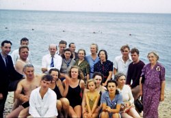 Continuing the archeological excavation of my father's slides, we find ourselves soaking wet, and in the company of a group which may include some of the youth group seen recently (https://www.shorpy.com/node/6042). Guess Dad's behind the camera, but that's his father, Steve, wearing the blue stripped tie. His mother, Elsie, is two to the right (green dress); her sister, Marcella Anna Peiser is in the dark blue dress. Between the two sisters is Aunt* Luna Depp (tentative identification); Her husband, Pete, is bottom left (dark trunks). Kodachrome, Kodak Retina, likely late '30s, vicinity of Newark, NJ, possibly Cherry Beach on the north shore of Long Island. View full size.
*actual relationship not determined.
Steve Miller
High and dry someplace near the crossroads of America
Happy groupThis looks like a fun bunch of people.  The fact that the photo is in color makes it look modern.
It Takes All KindsQuite an interesting array of clothing, from swimwear to business attire.  Then there's the guy on the right who appears to be wearing nothing but a sweater.
ModernIt's interesting to see how little this photo has dated. I could have sworn I saw the guy with the blue tie walking down the street the other day.
I agree with Capaha, it's fun seeing a photo this old in color.
(ShorpyBlog, Member Gallery)
