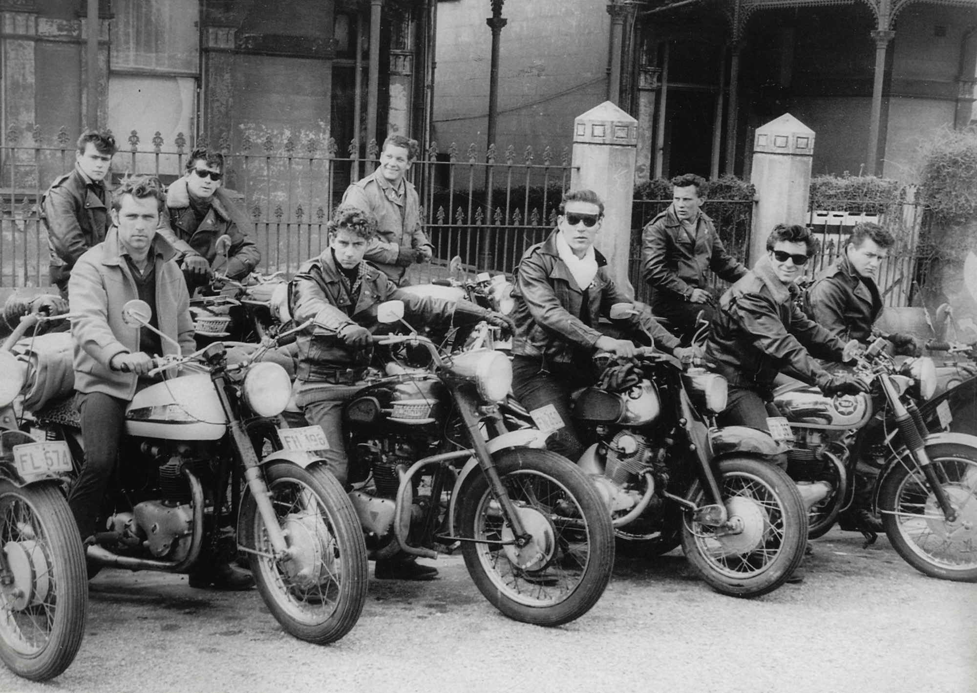 My father is the middle-most biker with the somewhat ill-fitting sunglasses, and the photo was taken in 1961 in Newcastle, NSW, Australia. Dad was seventeen at the time and had run away from home. He joined a traveling carnival, ended up working in a circus, then took up with a group of bikers. I think these were the Devil's Dozen. From memory, that leather jacket was stolen and it was the police that discovered this who sent him back on his way home to Bathurst, NSW. View full size.