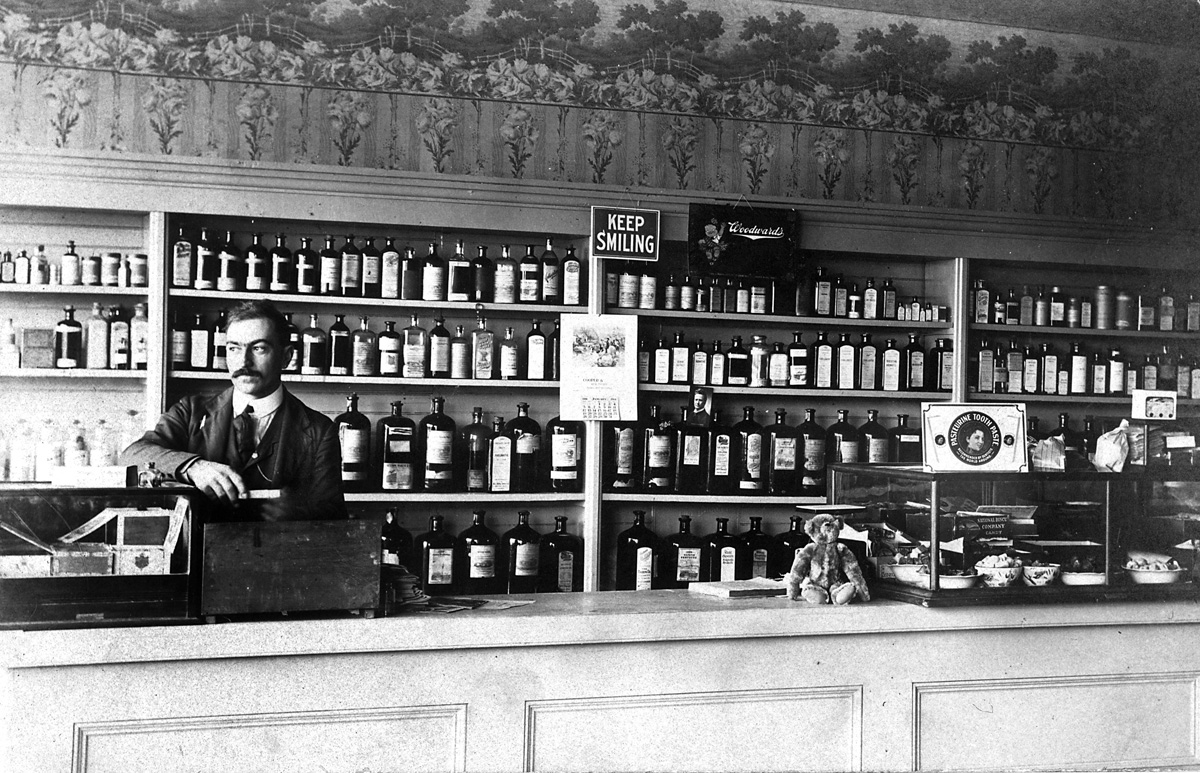 "Doc" Cutright at the counter of his pharmacy in Louisville, Kansas. The calendar reads March, 1902. He wasn't really and M.D. All pharmacists back then were called "doc." View full size.