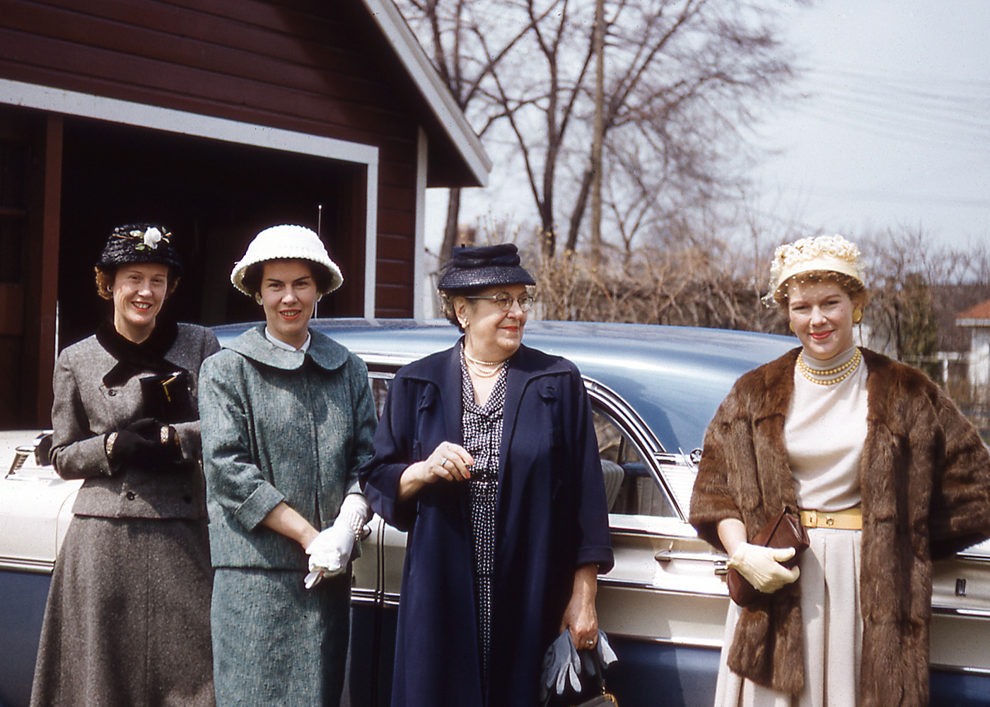 This was taken in 1958 in Windsor (then Riverside) Ontario. From left to right: my mother, Betty; Aunt Katherine; my father's mother; and Aunt Molly. One mile behind the trees is the City of Detroit. Everyone is ready for the Easter service at the Riverside United Church. My grandmother and the two Aunts were visiting from Toronto, and there was always a traditional shopping spree to Hudson's famous department store in Detroit. This Kodachrome was taken by my father, John McIntyre, with his Leica camera. He worked at Ford and I think the car is a Monarch. My father and Aunt Katherine still live in Toronto. View full size.