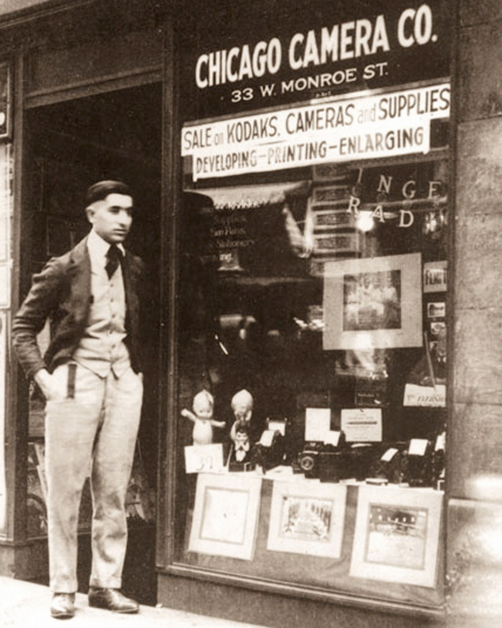 My grandfather Edwin Shutan in front of the store he owned: Chicago Camera, circa 1918. He sold many items besides cameras. You can see Kewpie dolls in the window. He also sold pen and pencil sets. A few years later, he changed the name to Shutan Camera. View full size.