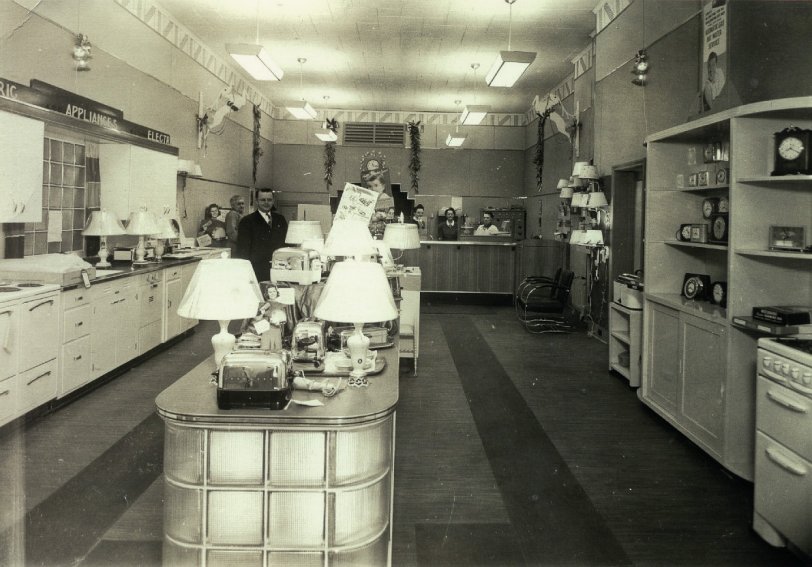 I wish I knew where this store was located.  I'd like to park my time machine outside and shop here for a while.  Sadly, the photo has no identifying information on the back. View full size.
