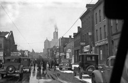 This photo was probably taken in the mid to late 1930s. Circus animals were walked through the streets to get to the arena from their train. From the taller buildings in the background it looks like we are looking up Broadway toward downtown. We can see the Liberty Bank building with a small Statue of Liberty visible on its top and I believe the Rand building (to the right). Both buildings are still there. 
Just to the left of the elephants there is a sign on the building that says "Circus April 10-?." The second date is blocked. This is obviously where they are headed.
It looks like we had some not too unusual late snow in Buffalo. View full size.
On Broadway!This is a view down Broadway from Pine St.  The building on the left with the sign is the old Broadway Auditorium, now the Buffalo Public Works Department garage.
A history of the Broadway Auditorium as a hockey venue is here.
(ShorpyBlog, Member Gallery)