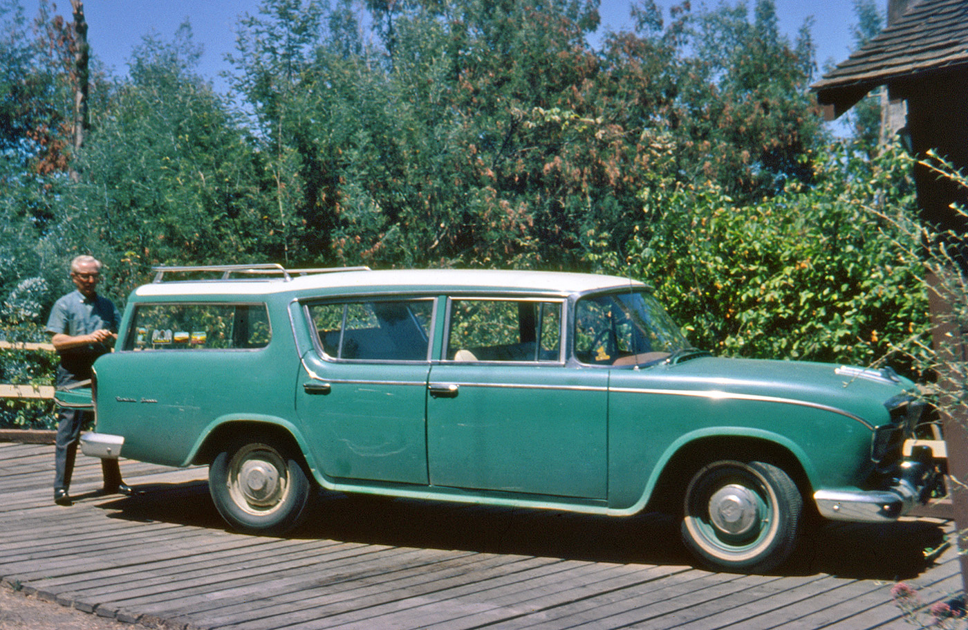 If you think this is just a photo of a well-worn old car, you're wrong. It's actually a significant moment in our family's history. June 27, 1966 was the last day for our 1956 Hudson Rambler. Previously, we saw it all shiny and sparkly, mere days after we got it. During the following ten years, it: took my sister to the church for her wedding; took us to graduations, my grade and high school and my brother's college; took us on our first visit to Yosemite, and later our very first camping trips (see our decals?); took my folks to visit their first grandchild; and perhaps most important of all, took me to my first visit to Disneyland.

I decided to record the event in a series of Ektachrome slides. Here, my father is clearing out all our personal items prior to the trip to the dealer to pick up our new car - a 1966 Rambler Classic station wagon. Oh; our trade-in allowance for this one: $50. View full size.