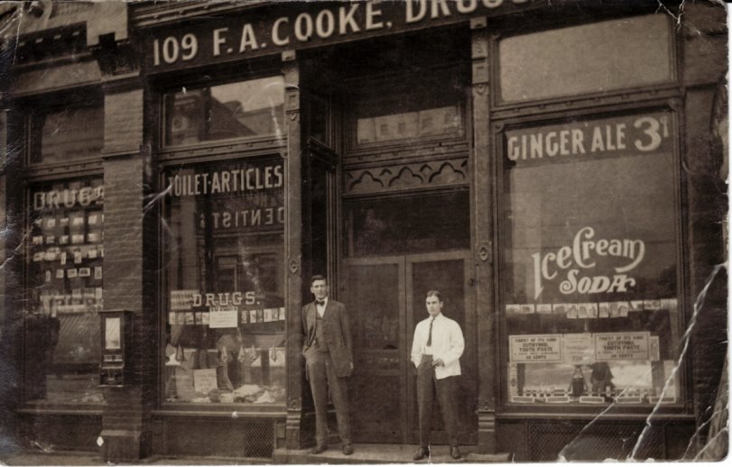 F.A. Cooke Drugs in Chicago, early 1900s. The image has a rare wooden candy vendor mounted to the exterior wall. One of my coin-op reference books shows a similar machine called a "Combination Vendor" from Ryede Specialty Works, c. 1910. View full size.
