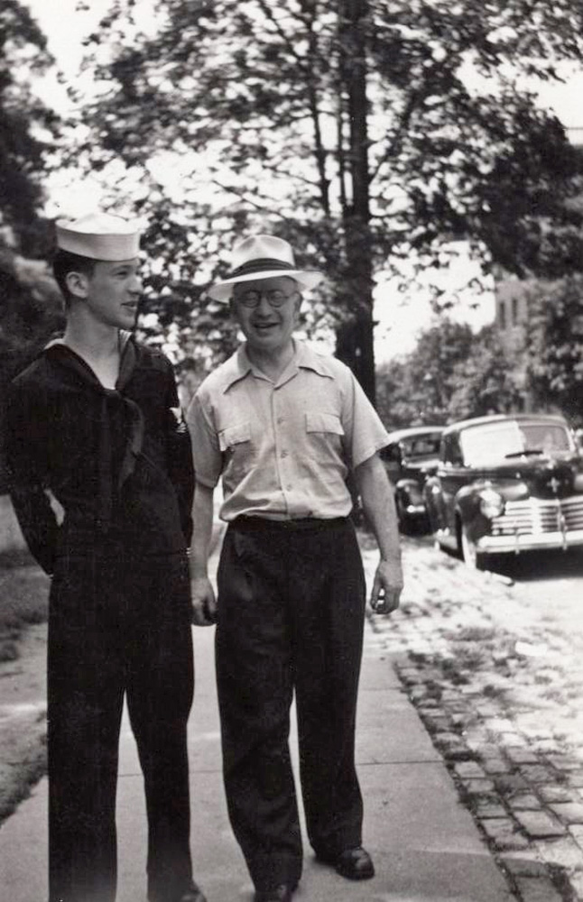 My (future) father, then 20 years old, stands in his new uniform for a photo with his father Max in 1944 in the Bronx, NYC. Though he received his induction letter at the start of the war he requested a deferment to complete his college degree in electrical engineering, which the government granted. After graduation, he chose the Navy because (he later said) he thought there would be fewer guns on a boat. The Navy decided to station their new engineering graduate in Chicago for radar antenna training, rather than assign him to a ship. 

While he was in Chicago the war ended and they deployed him to the Philippines to relieve service members who had maintained the Subic Bay radar during combat days. Because his enlistment was made during WWII he was a veteran, though the heaviest action he actually saw during his deployment was learning how to say “I think you are a beautiful girl” in Tagalog. He could recite that line in Tagalog, and several other dating lines he learned, for the rest of his life. 

Photographer is unknown. It might have been his older sister. Scan was made from a print.
