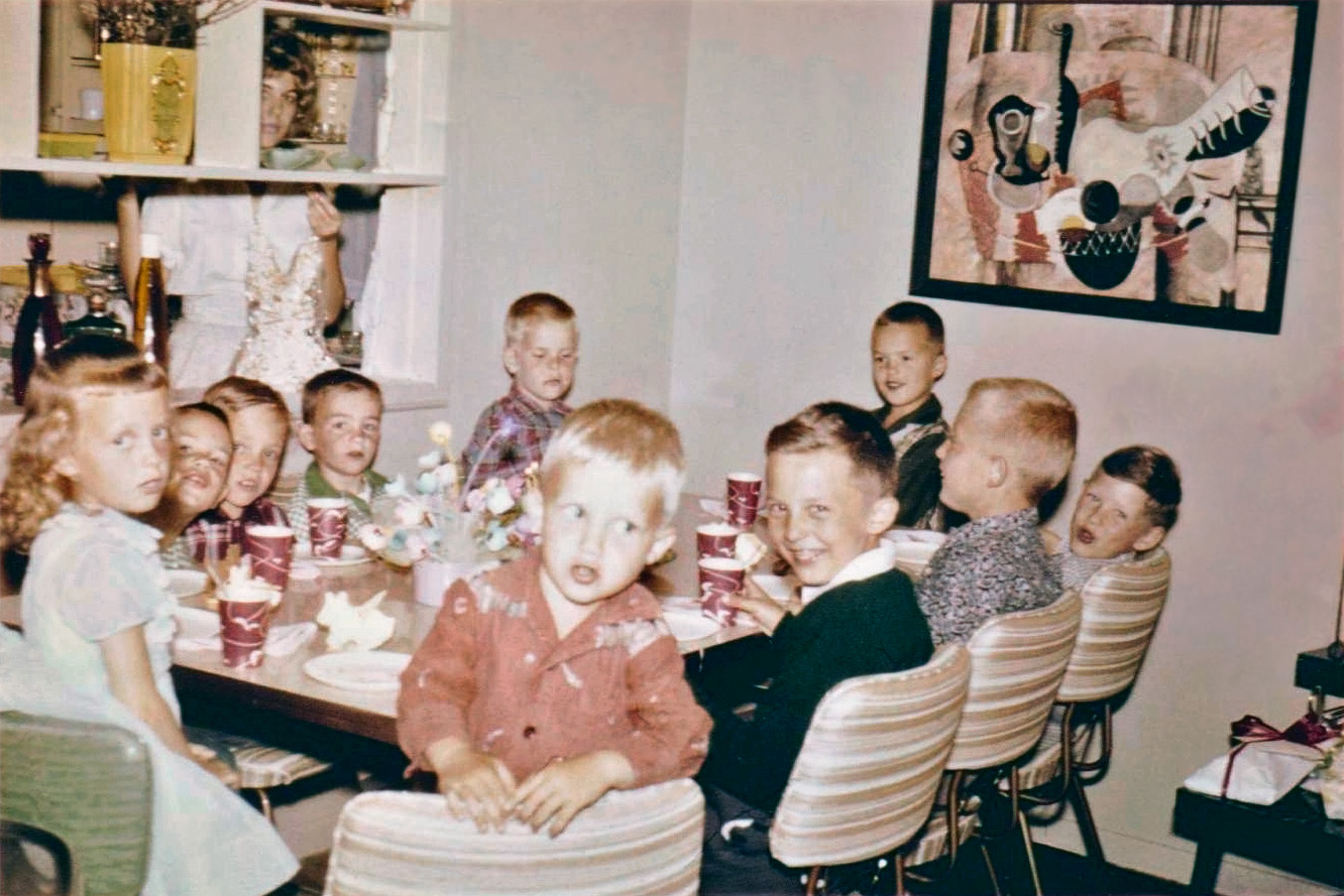 This is a photo of my sister Becky (the little girl far left) at her birthday party; I'm unsure of the year. I love how Mom is either spying on the goings on, or hiding from the camera! A note about the artwork on the wall: my Dad was a graphic designer, and that piece is an example of his work. Sadly, it was lost in a move many years ago. View full size.