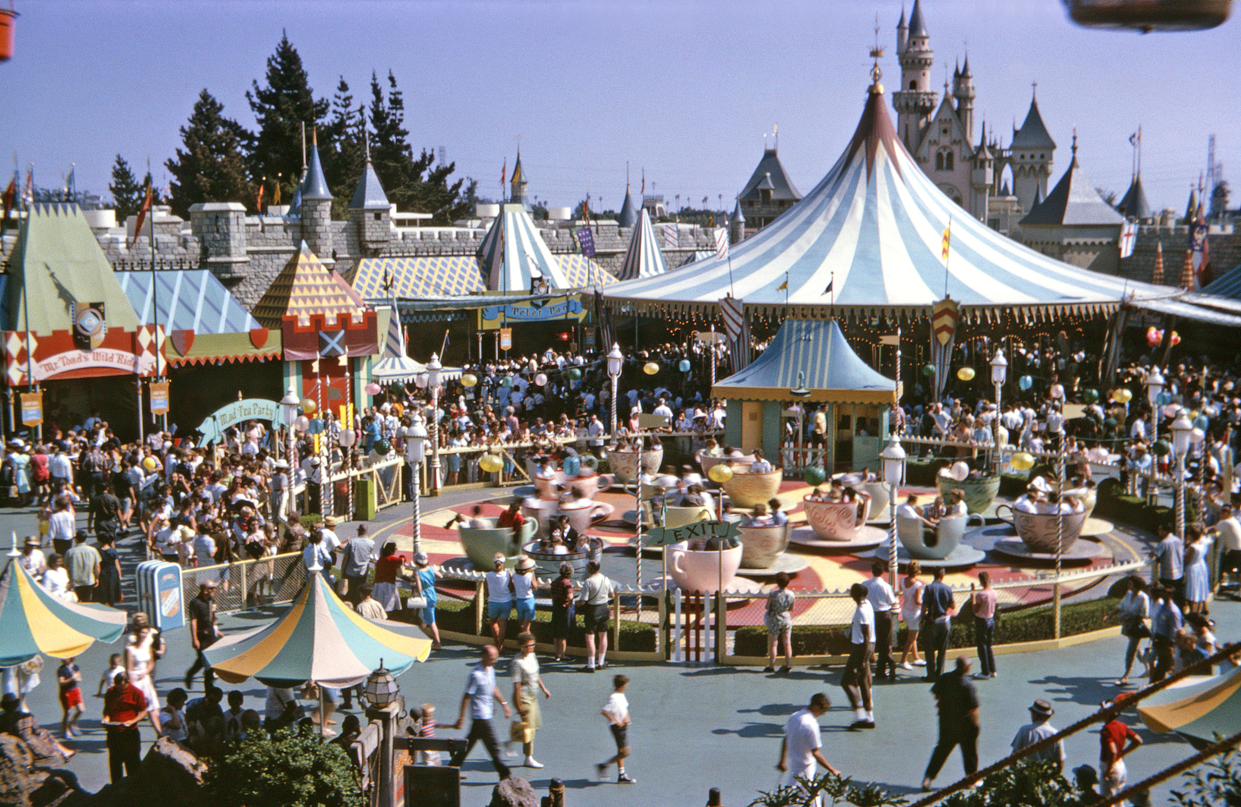 Kennedy-era folks at Disneyland in Kodachrome. Should I go on here about how thoroughly obsessed I was with Disneyland in the 1960s? At first I ached to go there just to drive the Autopia cars. The real fixation started after my first visit in 1960. It was like another world -- actually, a multitude of other worlds, all of them ones I'd rather live in. That being not quite possible, I settled for the next best thing: bring it into my real life. I organized the hundreds of color slides I took into elaborate shows with music and even printed programs. I drew and painted Disneyland artwork. I dubbed my cactus garden "The Living Desert" and tape-recorded a narration for walks through it. I built my own Storybook Land in one corner of our garden, and a diorama in the basement. I insisted we start having our Sunday dinners in the dining room so I could wheel the TV set around in order to watch  The Wonderful World of Color -- in black-and-white. I sent an inquiry about employment in the park, but they weren't hiring teenagers who lived 400 miles away. Even now I think I'd really like to live there, or at least the one of the 50s and 60s. Must be a Peter Pan complex. View full size.