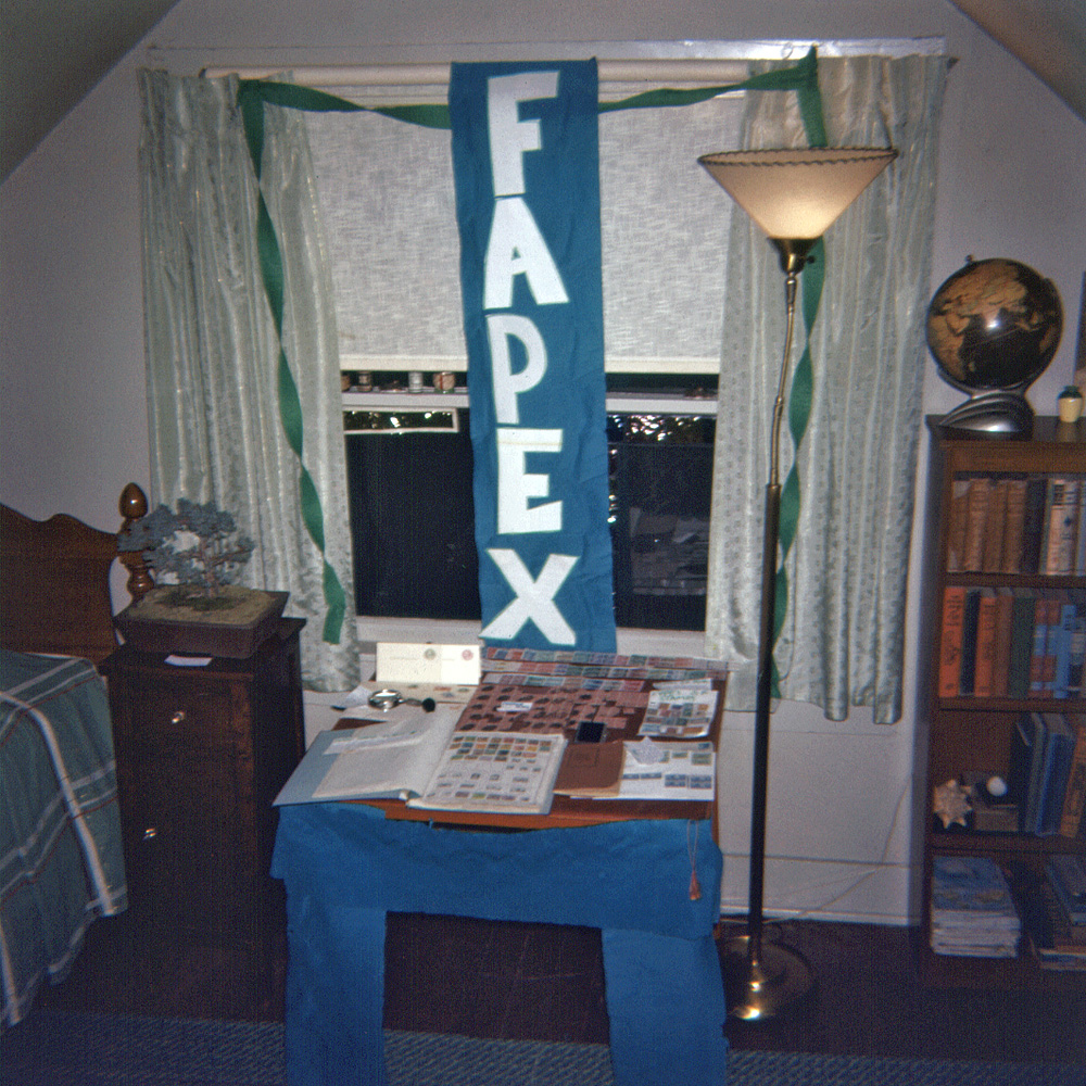 February 1961. FAPEX, the First Annual Philatelic Exhibition, set up in my bedroom. Obviously taken before opening, as otherwise the exhibit would be obscured by the throngs attending. Or maybe this is one of those time exposures where all the people were moving. Anyway, my stamp collection, enhanced by my 15-year old delusions of grandeur. I still have the stamps, but I wish I had the goose-neck floor lamp and Rocketeer-style illuminated globe. I am still using that bedstead, however, every night. 127 Ektachrome slide.

Oh; there was no Second Annual Philatelic Exhibition.