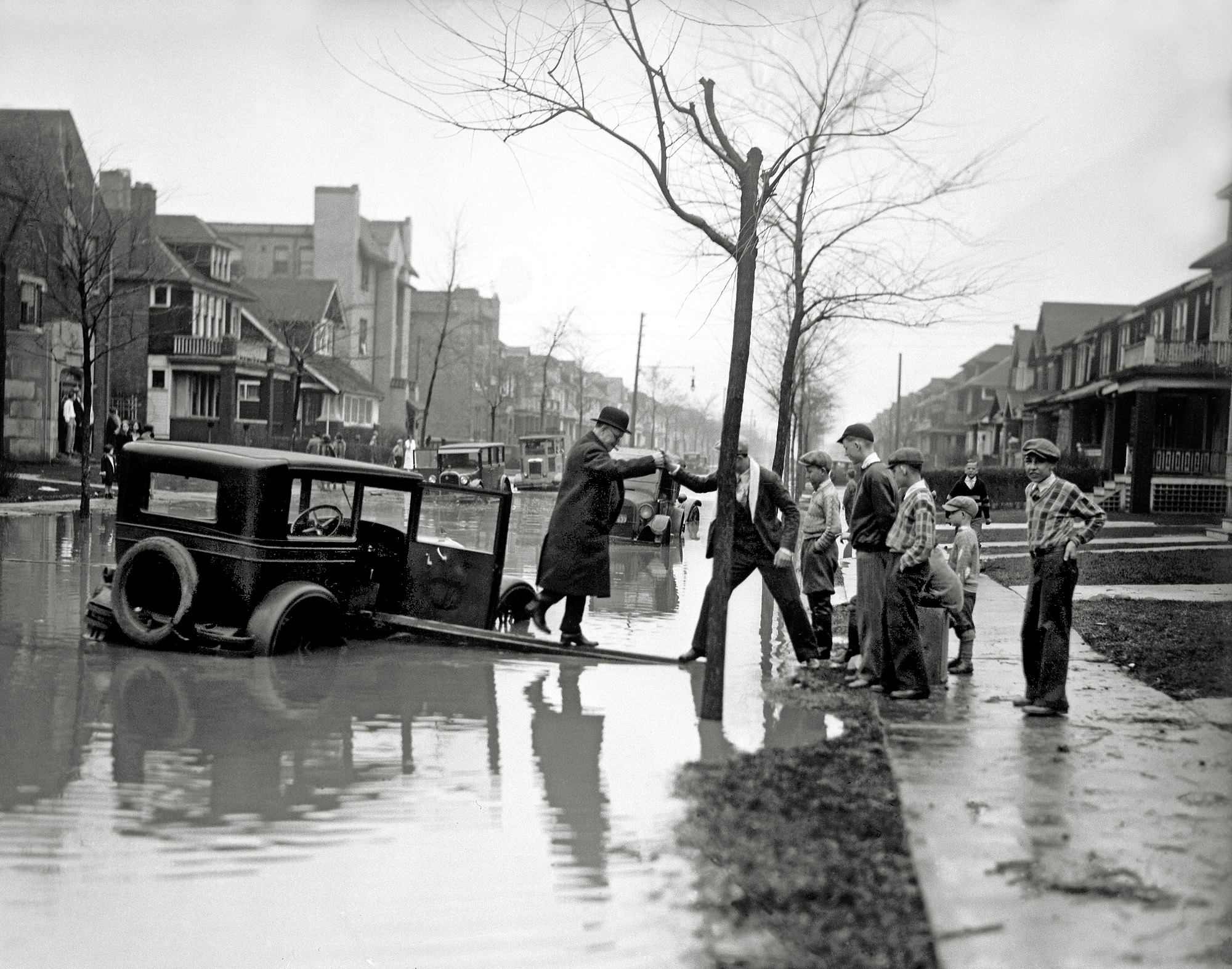 An obviously dedicated cigar smoker being rescued from his partially submerged car in Detroit from 1926.  From an inherited collection of 4x5 glass negatives. View full size.