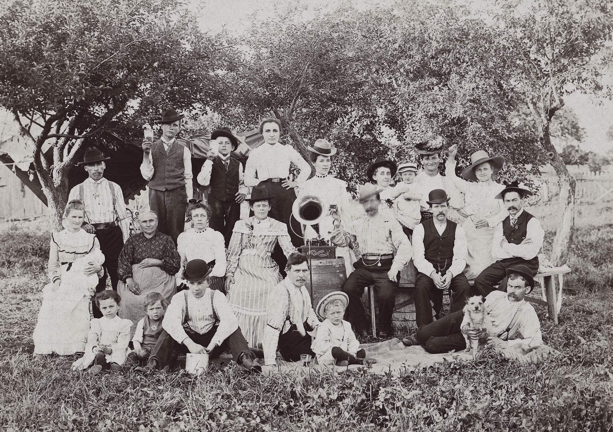A large group (extended family?) enjoys music outdoors on an Edison Standard Phonograph, circa 1902. The photographer's stamp on the rear of the mount indicates it was taken in the Milwaukee area.