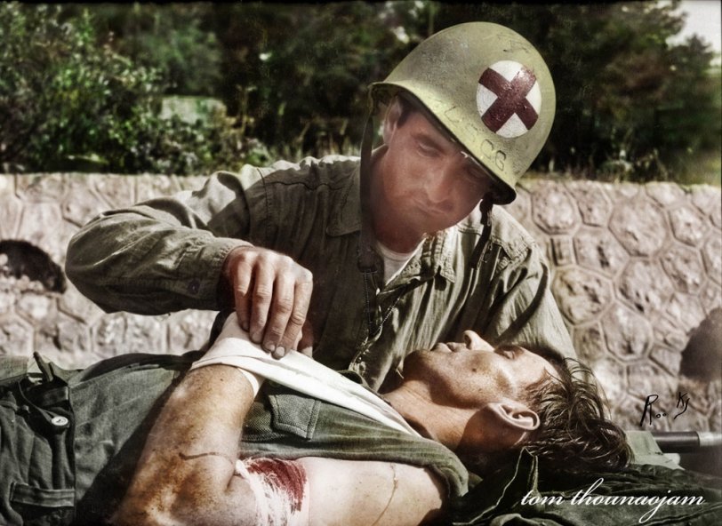 In this image, my grandfather John "Jack" Baker can be seen treating a captured German soldier. It is believed that this image was taken in Southern France – possibly near Baie de Cavalaire. Although the exact date isn’t known, it is likely that the event took place from August 15, 1944 to September 10, 1944. This image was taken by Dale Rooks, and may have been featured in a news magazine at the time. The date estimate is based on the official history of the USCG USS Duane, which Baker and Rooks were both assigned to. View full size.
