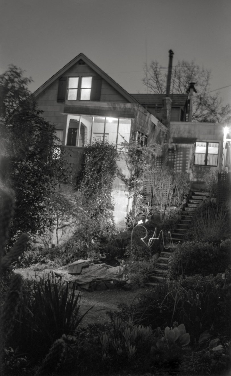 Shorpy being the Historic American Photo Archive, and me being American and at this point in my life historic, I present from my archive a nighttime photo experiment I performed in winter 1962 while a teenage camera geek. This is how I made this time-exposure of our Larkspur, California house: I turned on all the lights in the front-facing rooms, also those on the porches and front walk, and added one more (my desk lamp) below the front porch. I set up the camera (an old c. 1920 folding job) in the cactus garden, opened the shutter, ran down to the bottom of that stairway and wrote out my name with a little flashlight, then ran back up and closed the shutter. Voilà! I used that old camera, a Kodak Folding Autographic Brownie 2A, because it was the only one around the house then that could take time exposures. No tripod receptacle, so I had to balance it on something or other. (I know it's winter because of the burlap sacks covering the lantana for frost protection. Oh, and before you ask, no, we're not related to the Addams family.) Scanned from the original "116" 2½ x 4¼ negative, slightly cropped at top. View full size.

