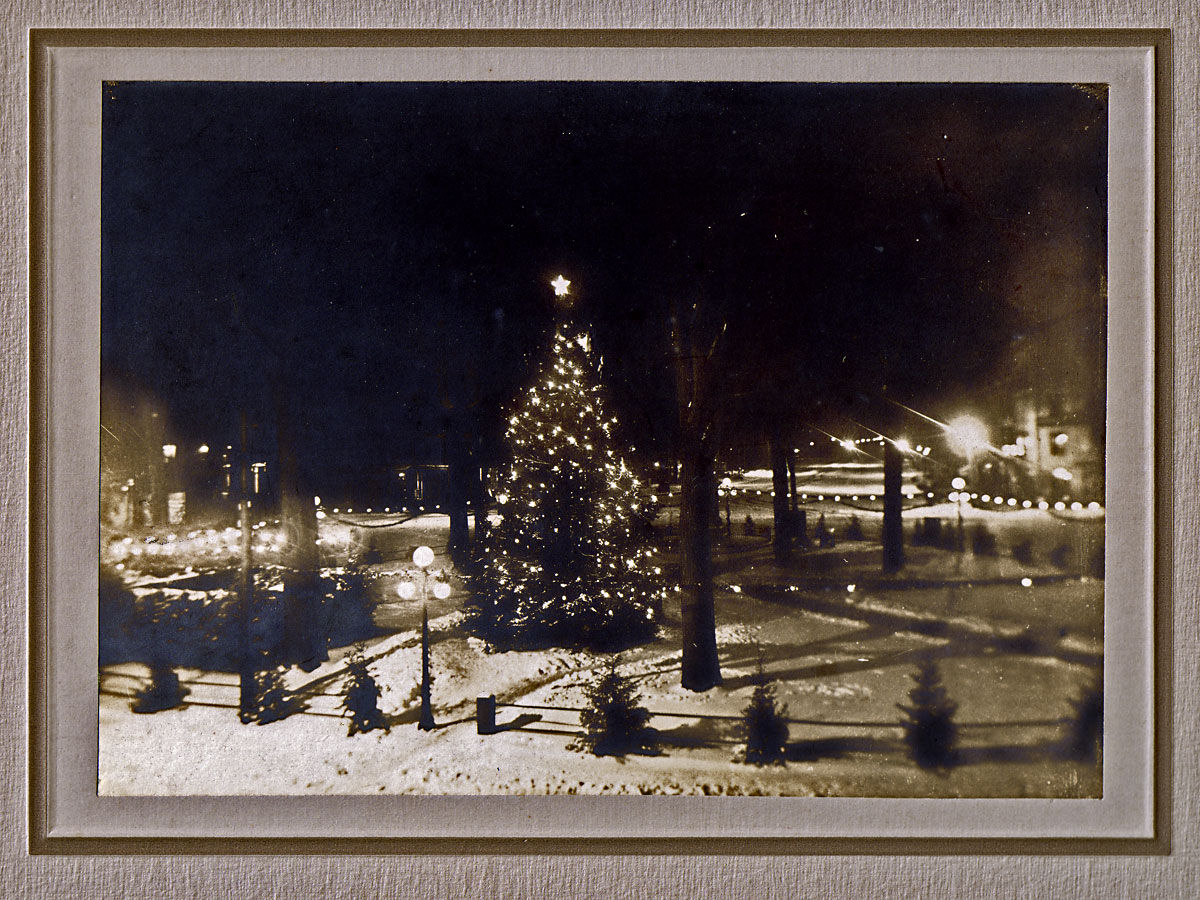 Illumination on the Common, Keene, NH, Christmas Eve 1913. If I've got the orientation correct, the bit of white behind the bright light at right is the Congregational Church at the head of the square. This 50-foot spruce was Keene's first community Christmas tree.