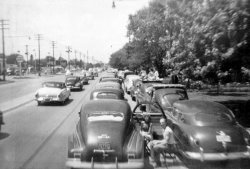 My grandparents sitting on 16th Street (literally) in Speedway, Indiana a full two days before the running of the 1955 Indianapolis 500 waiting to get in. The car? A 1941 Oldsmobile. The photo isn't the best but conveys how big the event really was. Quite possibly my dad might have taken the pic from standing atop another car. In those days there was no such things as "crumple zones"! View full size.
Any more?It would be great if you have more and could post them, too!
Indy 500 JamThe car to the right of the '41 Olds is a '48-49 Hudson.
The cars to the left are 1951 Mercury with fender skirts:)
ahead of that appears to be a '46-47 Olds.
I know the excitement of waiting to get into a race, tailgating with no tailgates. Cool! 
(ShorpyBlog, Member Gallery)