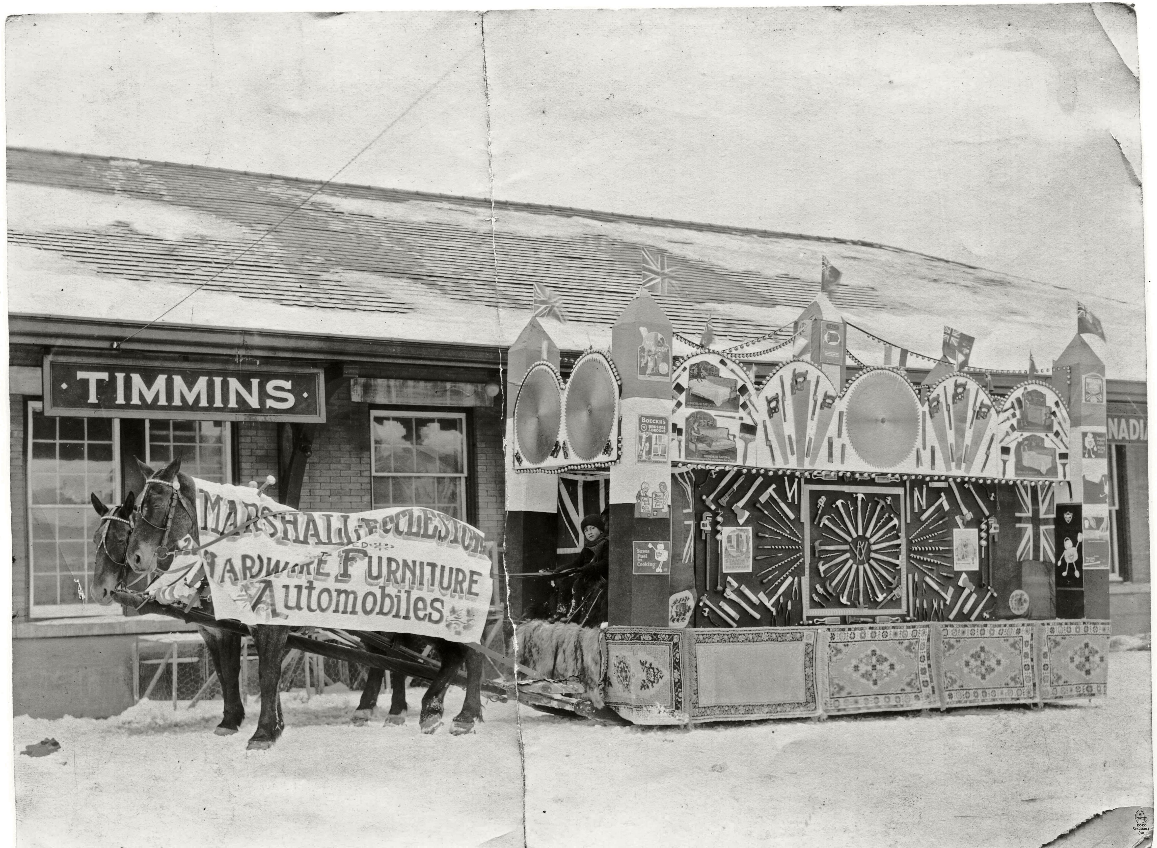 Horse-drawn Marshall-Ecclestone Furniture & Hardware store parade float in front of the Timmins, Ontario, railroad depot.

Grandfather worked at the store as a young man and likely had a hand in constructing this display of the variety of tools and supplies available there.

Similar photos in the collection are dated 1927.
