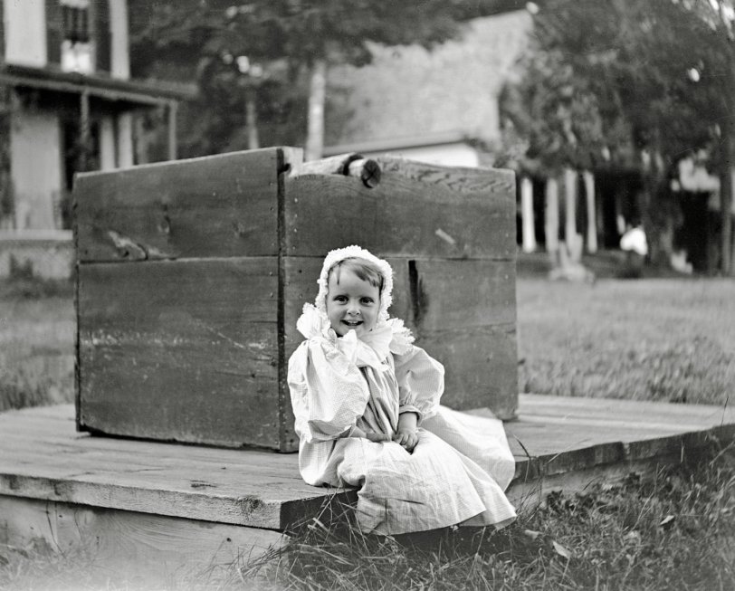 The baby is so happy she is on the well curbing. A glass negative found in Maine. View full size.
