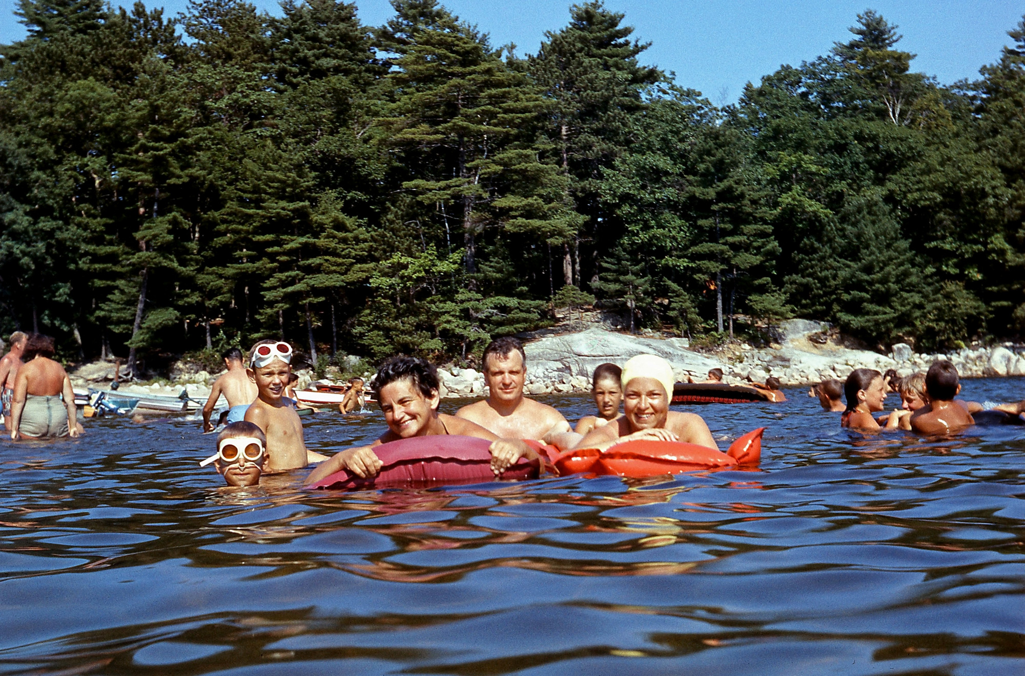 Sebago Lake, Maine, 1959. Dad ventured up to his chest with his Yashicaflex camera to capture this shot, Mom on the right, my brother with the nose plugs on the left, and friends met at the campground. This trial camping trip led to Dad buying a 9x12 high-side center ridge pole cotton tent and other equipment to go camping well into the 1960s. View full size.