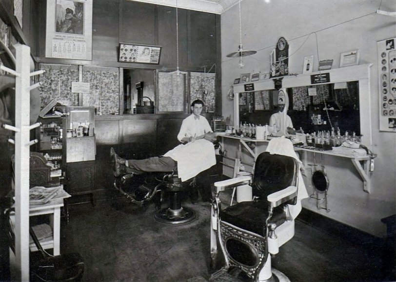 This is my grandpa, Aaron Betsch, in his barbershop in Streeter, ND. The date on the calender says 1928, so he would have been 24 and fresh out of barber college.
He is a classic example of an American success story. He was the son of dirt-poor, German-Russian immigrant farmers and only had a 3rd grade education. He decided there was more to life than breaking your back under a hot sun, so he worked his way through barber school (Mohler Barber College, Fargo, North Dakota. It's still there!) and quickly bought his own shop. My grandma did the bookkeeping, and he retired as a very successful businessman. He is proof that you can do anything if you set your mind to it.
He passed away in 1995, and he had some great stories from back in the day. He said he used to keep his barber shop open until 2 a.m. or later on Saturday nights, because the farmers would come to town, get drunk, and then need a shave and haircut for church the next morning. So they'd all leave the bar and come across the street to his shop and wait their turn.
The shop had a coal-stove for heat, and in the winter, he had to wake up at 3:00 every morning, walk the two blocks or so to his shop and throw more coal in the stove, otherwise the hair tonics and lotions would freeze in their bottles. This was every night, despite how cold or snowy the weather was. He once said to me "They call it the good old days. Well, I tell you, boy oh boy ... I sure wouldn't want to go back to those days!" View full size.

