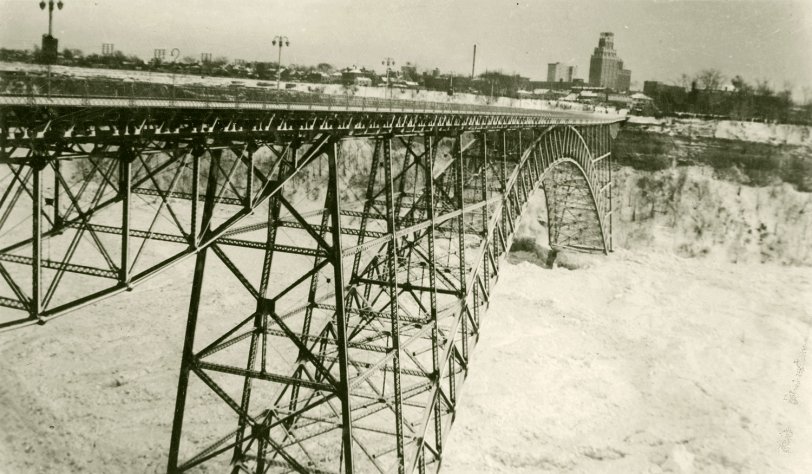 The Fallsview Bridge spanned the Niagara River below the falls between Ontario and New York. During the especially harsh winter of 1938, large quantities of Lake Erie ice were swept down the river, building up in the gorge below the falls. On January 27 the pressure of the ice on the bridge abutments caused a catastrophic failure of the structure (seen here). View full size.
