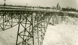 The Fallsview Bridge spanned the Niagara River below the falls between Ontario and New York. During the especially harsh winter of 1938, large quantities of Lake Erie ice were swept down the river, building up in the gorge below the falls. On January 27 the pressure of the ice on the bridge abutments caused a catastrophic failure of the structure (seen here). View full size.
(ShorpyBlog, Member Gallery)