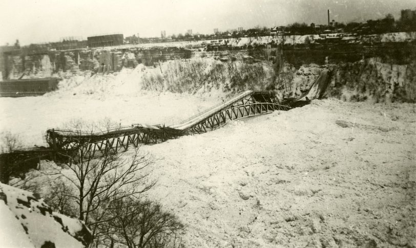 The Fallsview Bridge spanned the Niagara River below the falls between Niagara Falls, Ontario and Niagara Falls, New York (seen here). During the especially harsh winter of 1938, large quantities of Lake Erie ice were swept down the river, building up in the gorge below the falls, On January 27, the pressure of the ice on the bridge abutments caused a catastrophic failure of the structure. View full size.
