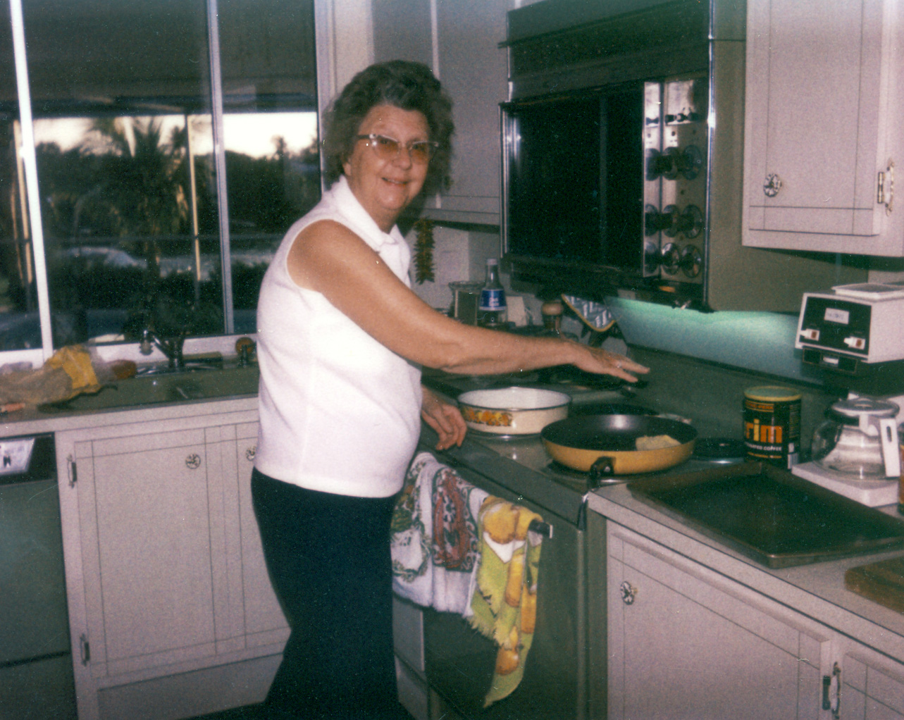 Here is my mother in her retirement home kitchen in Naples, Florida circa 1979. She always loved to cook the fish my dad caught in the gulf. If there was more fresh fish than they could eat, she froze them in a coffee can for later meals. Looks like Brim this week. Dad's boat can be seen through the kitchen window. View full size.