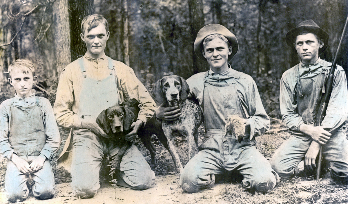 These are my great-uncles, L-R, Lee, Milton, Frank and Jim, the Jamieson brothers, with their hunting dogs in 1910. I assume the squirrel was for supper. My grandfather, who was just a kid, was hiding in the woods as he was too shy to have his picture taken with his brothers. This picture was taken somewhere around Falkner, Mississippi around 1910 or so.