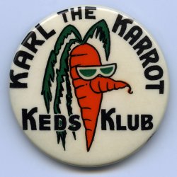 This button was a promotional piece about 1-3/4" in diameter, given out by shoe stores on the purchase of a pair of Keds, one of the sponsors of the daily kids' show "Fireman Frank" broadcast by KRON-TV in San Francisco during the mid-50s. Fireman Frank was George Lemont, a hip SF deejay who stepped into the role after the original Fireman, a roly-poly avuncular gent more in the style of a kids' TV host, dropped dead. Lemont's humor appealed as much to adults as well as kids; you could hear the studio crew guffawing off-camera at things that went over our heads. Between cartoons, Lemont brought out his cast of puppets, including robot Dynamo Dudley, the beret-wearing, bop-talking Scat the Cat and best of all, Karl the Karrot. Karl, as you can see, was a sort of proto-beatnik, literally a carrot with a pair of shades. His dialog consisted entirely of "blubble-lubble-lubble" while he thrashed about, chlorophyl topknot flailing. At home, we were all in convulsions on the floor.