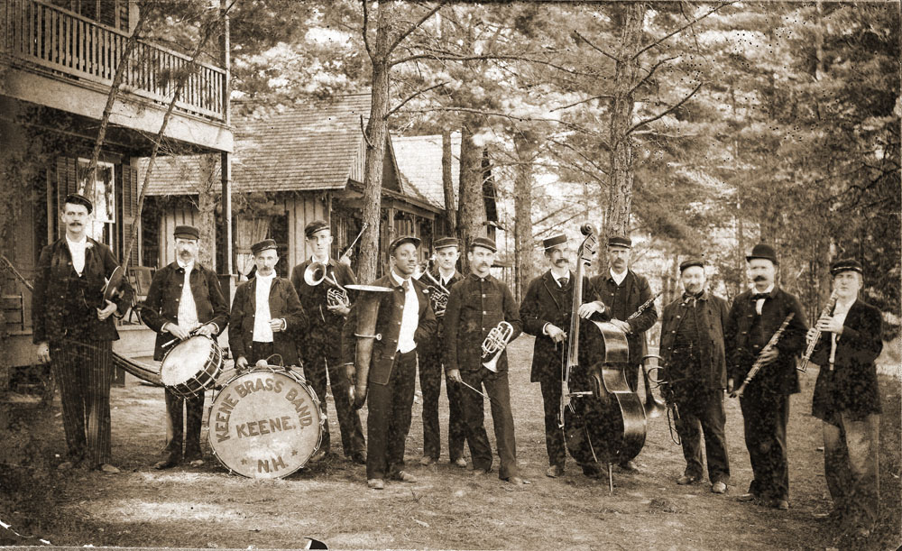 When my maternal grandfather, F. Harold Tyler, captioned this picture, there were a few unknowns.

Location: Forest Lake, New Hampshire. Cymbals - ?, Drums - Allie Tyler, Bass drum - John Barrus, Alto - (Harry Alexander scratched out), E-flat Bass - Cooper (ran a restaurant where Beedle Music Co. was on West Street), Alto - Harry Alexander, Cornet (leader - ?), Bass Viol ___ Hill, Clarinet - Fred Farr and Summer White, E-flat Clarinet - Geo. Bowker, Trombone (between Farr & White) - Norm Davis. Music runs in the family. "Allie" Tyler would likely have been my great-grandfather. This is the only time I've seen that nickname, he was Albert. Harold was best known in later life as a flute and piccolo player, though he played in a drum corps as a young man. The photo was likely taken prior to 1900.