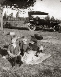 My grandmother up front left in this picture along with her siblings, taking a break on their journey to Yellowstone from Burley Idaho, around 1920. Imagine making the journey on the roads back then in those old cars back then.  View full size.
(ShorpyBlog, Member Gallery)