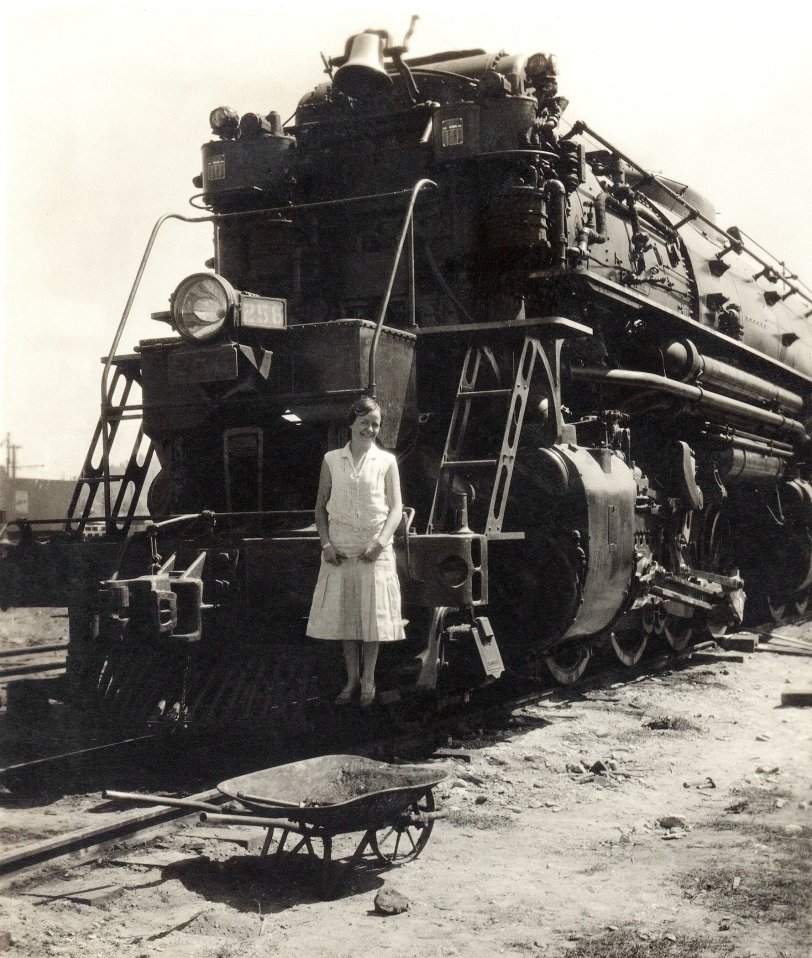Portola, California, September 2, 1931. My mother-to-be posed by my father-to-be in front of Western Pacific 2-8-8-2 articulated locomotive #256. WP articulated locomotives were known to employees of that railroad as a "Malley," for Anatole Mallet, who invented the compound articulated locomotive; WP "Malleys" were articulated but not compound. 
The standard reference for Western Pacific steam locomotives lists a build date of 1938 for #256. This is probably incorrect, as the builder's number is one past WP #255, and the official road diagrams list Road Class 251 followed by Road Class 257, which puts #256 in the earlier group. Taken out of service in 1950 and scrapped in 1952. View full size. 
