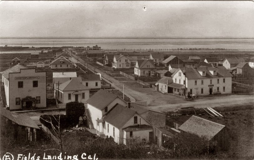This is the town of Fields Landing on north side of Humboldt Bay in Calif. The main road that goes to the foot of the bay leads to a whaling station. The large building to the front is known as the whalers inn. Postmark on this post card is dated 1912.