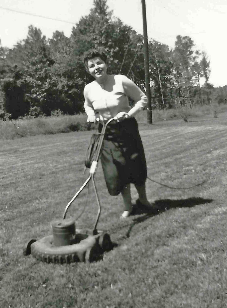 My mother never mowed a lawn in her life. But she did pose here, for my father to take her picture, in the back yard of our first Levittown Pennsylvania home. This is my mother pretending to mow the lawn.

What’s interesting about this picture is the actual mower. The year of this picture is 1954. Notice the cord trailing behind my mother, wrapped around the side of the handle, and plugged into the motor. This rotary mower was electric. And it was quiet. No two stroke motor buzz or starter cord to pull. Though my father bought it used from an ad on a bulletin board at work in 1953, because he owned no mower before he owned that house, it only dates from around 1950 or 1951. I found the identical mower for sale in a Canadian Sears catalog of that era. Paint color was a dark rust shade of red.
