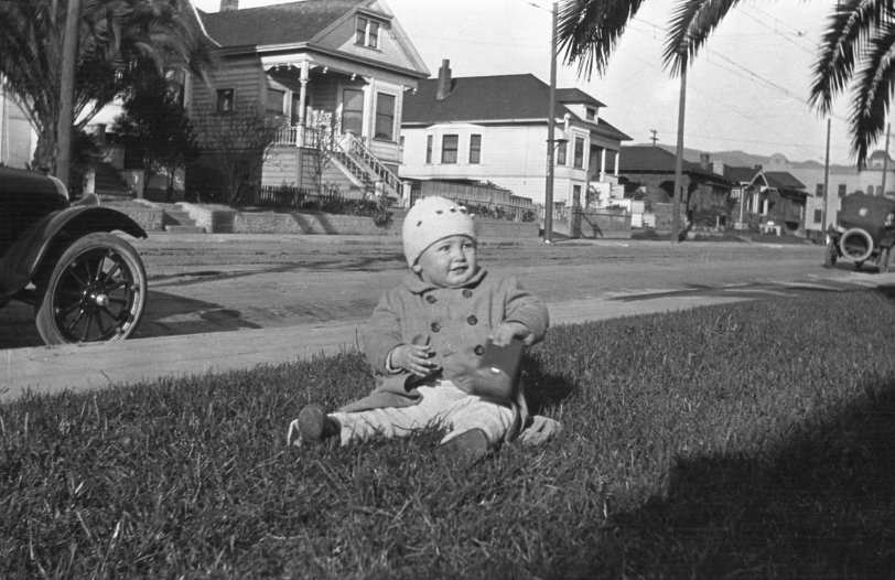 Unknown location, but somewhere where it can support the growth of palm trees. Happy kid playing in the front yard. From my negatives collection. View full size.
